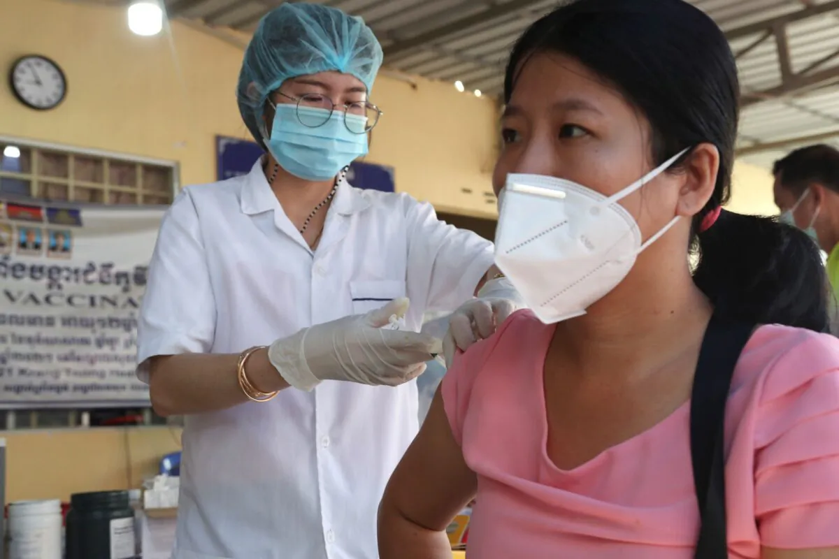 A Cambodian woman (R) receives a shot of fourth dose of the Pfizer's COVID-19 vaccine at a heath center in Phnom Penh, Cambodia, on Jan. 14, 2022. (Heng Sinith/AP Photo)
