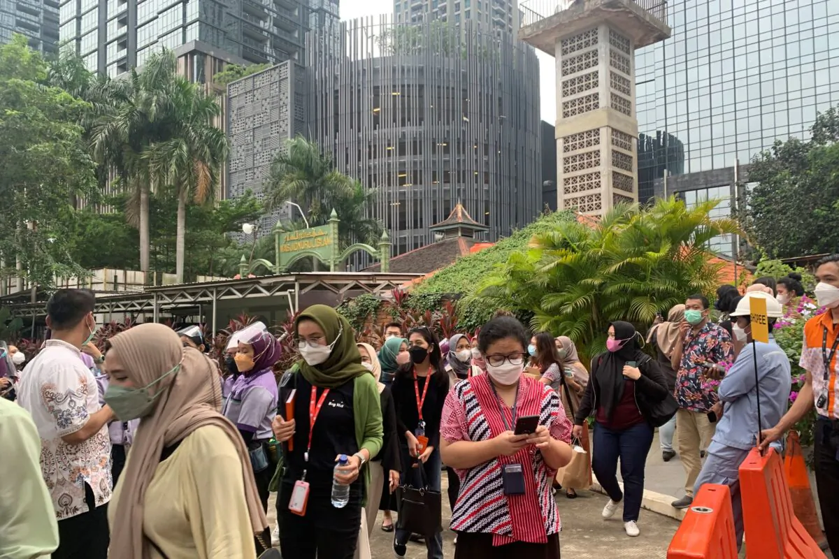 People wait outside as they have to evacuate their office buildings following an earthquake, at the main business district in Jakarta, Indonesia, on Jan. 14, 2022. (Tatan Syuflana/AP Photo)