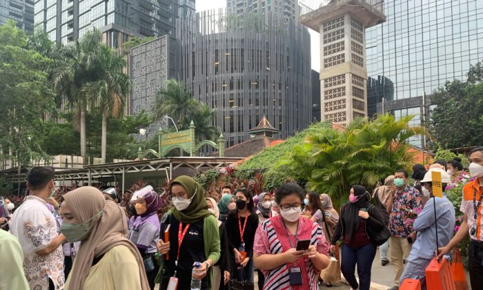People wait outside as they have to evacuate their office buildings following an earthquake, at the main business district in Jakarta, Indonesia, on Jan. 14, 2022. (Tatan Syuflana/AP Photo)