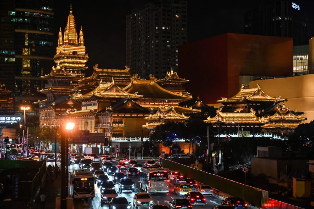 Vehicles make their way along a busy road past the Jing'an Temple in Shanghai, China, on Oct. 14, 2021. (Hector Retamal/AFP via Getty Images)