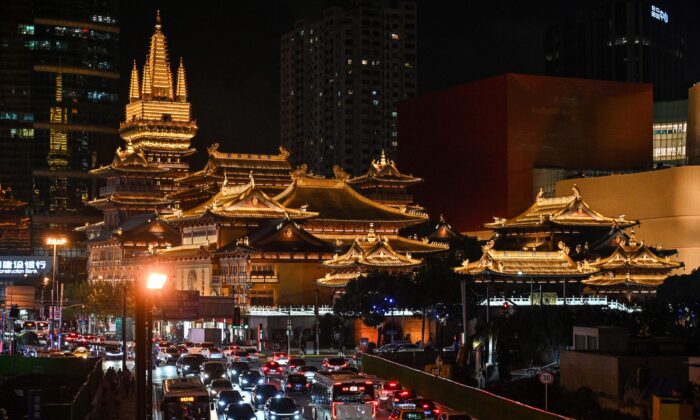 Vehicles make their way along a busy road past the Jing'an Temple in Shanghai on Oct. 14, 2021. (Hector Retamal/AFP via Getty Images)