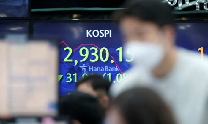 Currency traders watch computer monitors near the screen showing the Korea Composite Stock Price Index (KOSPI) at a foreign exchange dealing room in Seoul, South Korea, on Jan. 14, 2022. (Lee Jin-man/AP Photo)