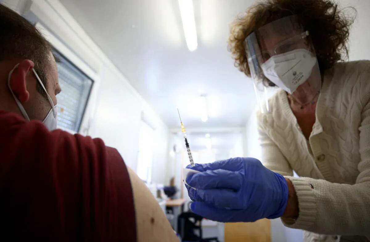 Doctor Eva Raunig vaccinates a person with a dose of the Pfizer-BioNTech COVID-19 vaccine inside a special container to use for general practitioners, called "vaccination box" in Vienna, Austria, on April 26, 2021. (Lisi Niesner/Reuters)