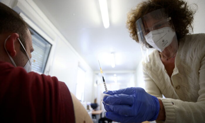 Doctor Eva Raunig vaccinates a person with a dose of the Pfizer-BioNTech COVID-19 vaccine inside a special container to use for general practitioners, called "vaccination box" in Vienna, Austria, on April 26, 2021. (Lisi Niesner/Reuters)