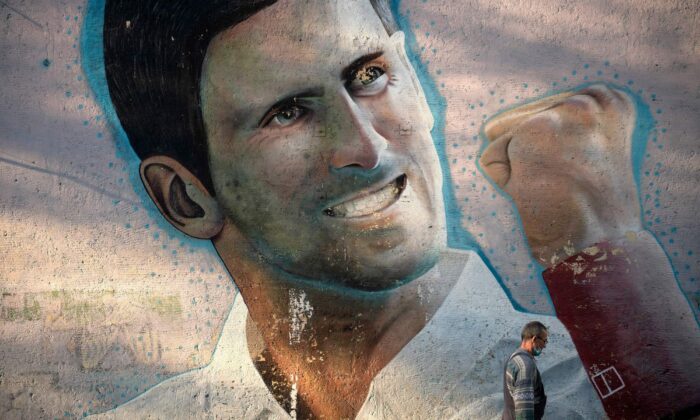 A man walks past a mural depicting Serbian tennis player Novak Djokovic, painted on the external wall of a primary school, in Belgrade, Serbia, on Jan. 14, 2022. (Oliver Bunic/AFP via Getty Images)