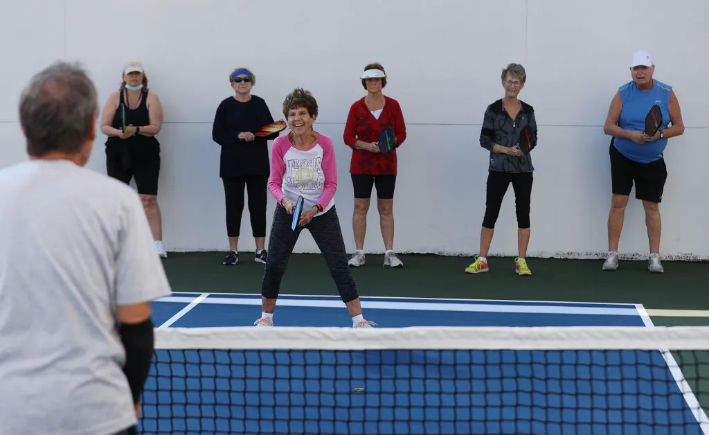 Pat Harrell (C) listens to Bob Savar as he teaches a pickleball class to a group vaccinated against COVID-19 at the John Knox Village Continuing Care Retirement Community on March 11, 2021, in Pompano Beach, Fla.  (Joe Raedle/Getty Images)