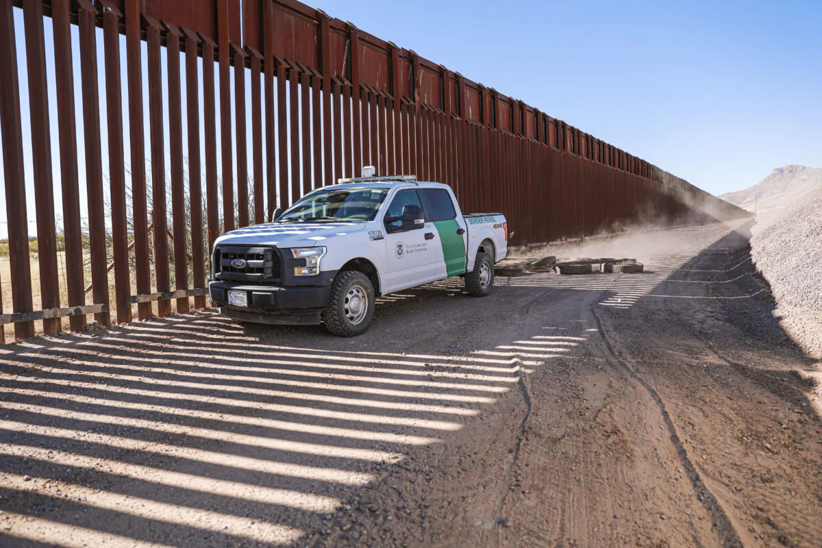 A Border Patrol agent pulls tires behind his vehicle to smooth out the road to make detecting footprints easier near Naco in Cochise County, Ariz., on Dec. 6, 2021. (Charlotte Cuthbertson/The Epoch Times)