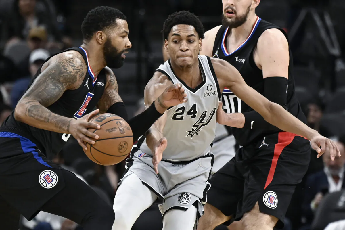 Los Angeles Clippers' Marcus Morris, Sr., left, drives against San Antonio Spurs' Devin Vassell during the first half of an NBA basketball game in San Antonio on Jan. 15, 2022. (AP Photo/Darren Abate)