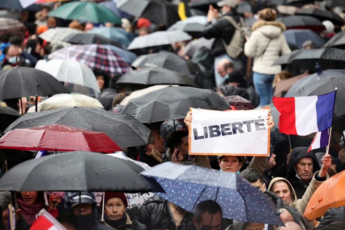 A person holds a sign that reads "Freedom" as people attend a demonstration to protest against a bill that would transform France's current coronavirus disease health pass into a ''vaccine pass,'' in Paris, on Jan. 8, 2022. (Sarah Meyssonnier/Reuters)