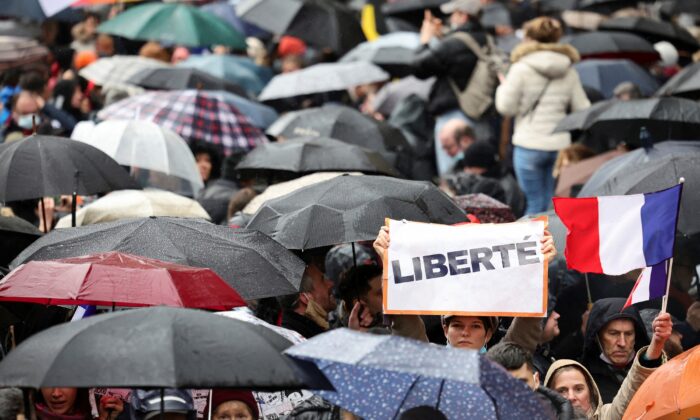 A person holds a sign that reads "Freedom" as people attend a demonstration to protest against a bill that would transform France's current coronavirus disease health pass into a ''vaccine pass,'' in Paris, on Jan. 8, 2022. (Sarah Meyssonnier/Reuters)