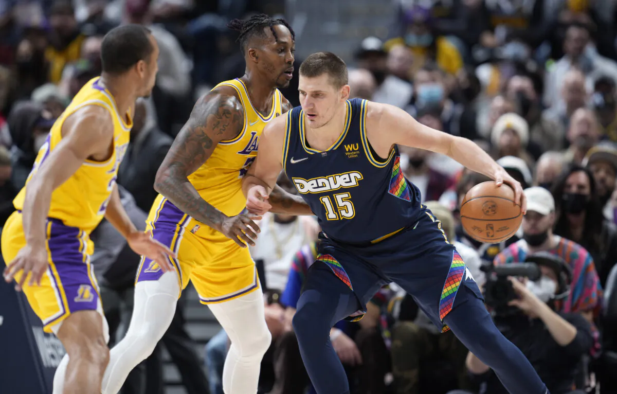 Denver Nuggets center Nikola Jokic, right, works the ball inside as Los Angeles Lakers guard Avery Bradley, left, and center Dwight Howard defend in the first half of an NBA basketball game in Denver on Jan. 15, 2022. (AP Photo/David Zalubowski)