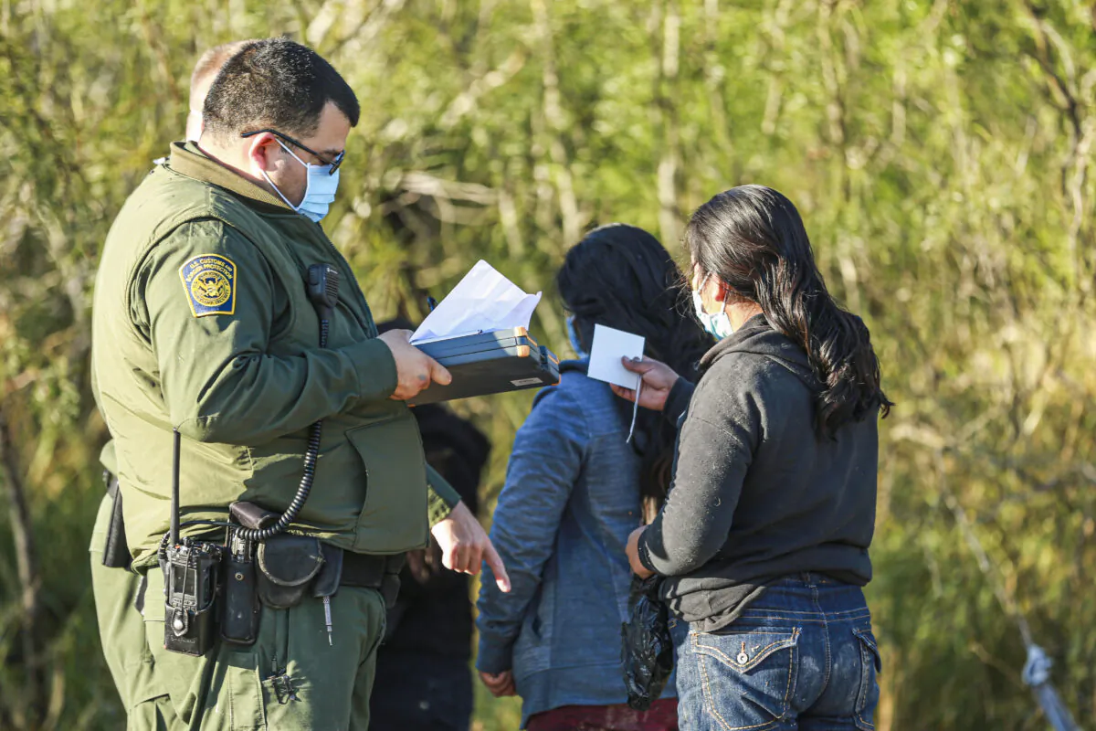 Border Patrol agents apprehend illegal immigrants after they cross the Rio Grande from Mexico into the United States, in La Joya, Texas, on Jan. 14, 2022. (Charlotte Cuthbertson/The Epoch Times)