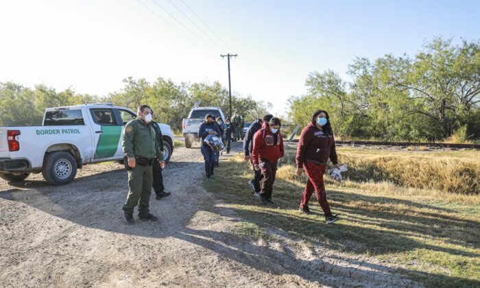 Border Patrol agents apprehend illegal immigrants after they cross the Rio Grande from Mexico into the United States, in La Joya, Texas, on Jan. 14, 2022. (Charlotte Cuthbertson/The Epoch Times)