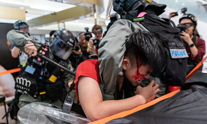A man was detained by riot police during a demonstration in a shopping mall at Sheung Shui district on Dec. 28, 2019, in Hong Kong. Anti-government protesters in Hong Kong continue their demands for an independent inquiry into police brutality, the retraction of the word "riot" to describe the rallies, and genuine universal suffrage. (Photo by Anthony Kwan/Getty Images)