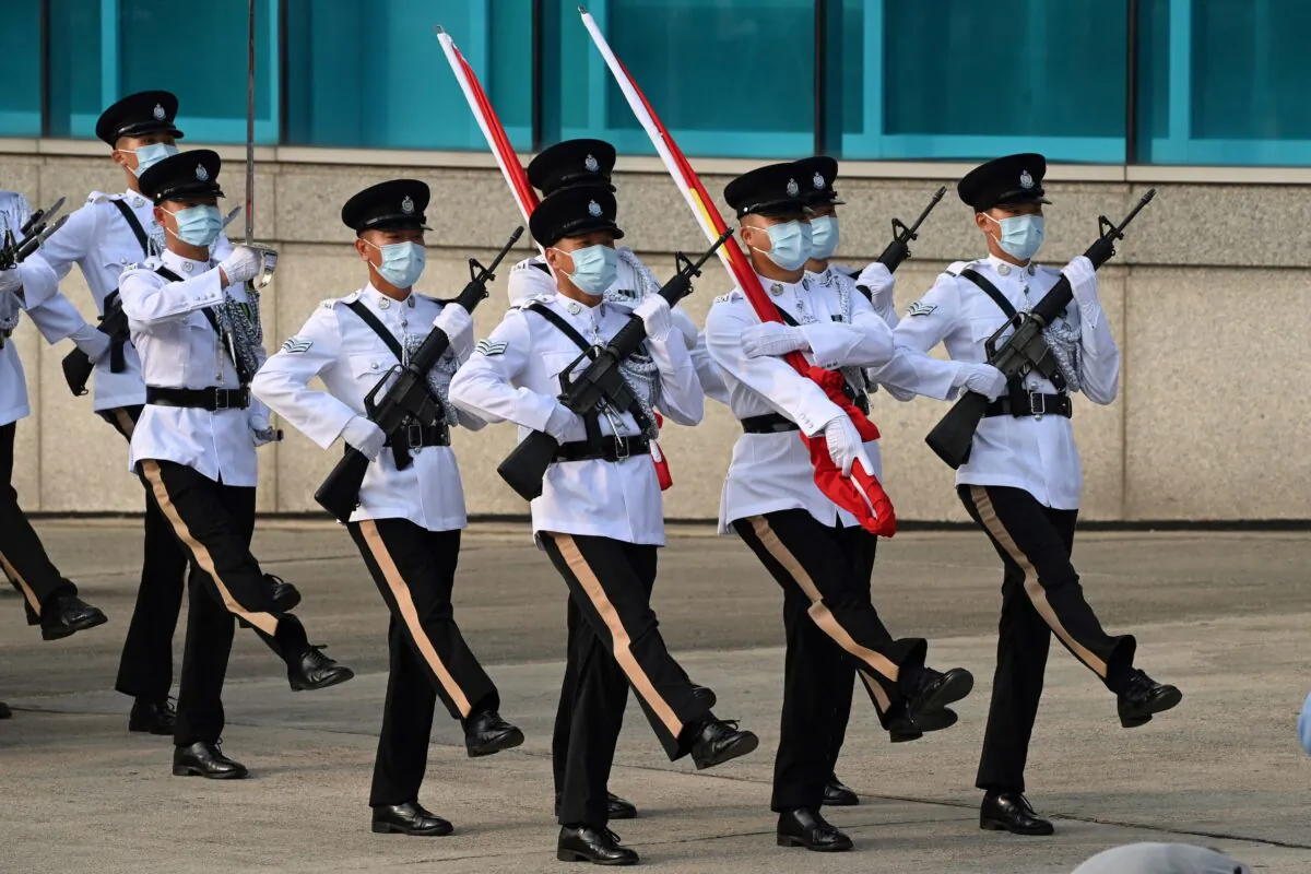 Police officers goose step as they take part in a flag raising ceremony to mark China's National Day in Hong Kong on Oct. 1, 2021. (Peter Parks/AFP via Getty Images)