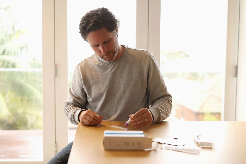 In this photo a man uses a COVID-19 rapid antigen test kit at home in Sydney, Australia, on Sept. 29, 2021. (Cameron Spencer/Getty Images)