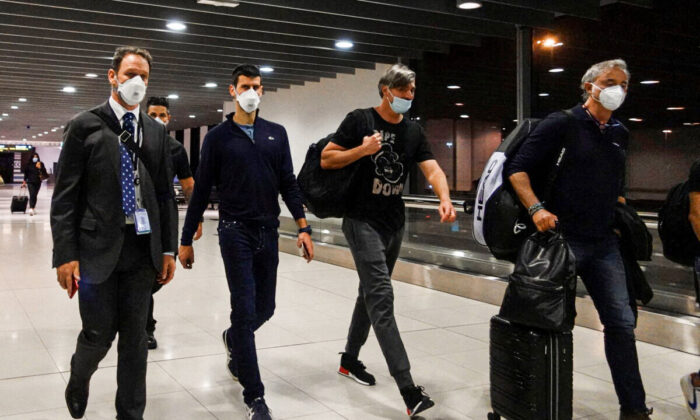 Serbian tennis player Novak Djokovic (2nd L) walks in Melbourne Airport before boarding a flight, after the Federal Court upheld a government decision to cancel his visa to play in the Australian Open, in Melbourne, Australia, on Jan. 16, 2022. (Loren Elliott/Reuters)