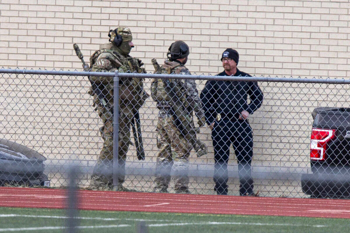 Law enforcement officials gather at a local school near the Congregation Beth Israel synagogue in Colleyville, Texas, on Jan. 15, 2022. (AP Photo/Gareth Patterson)