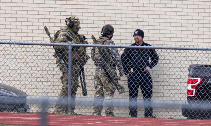 Law enforcement officials gather at a local school near the Congregation Beth Israel synagogue in Colleyville, Texas, on Jan. 15, 2022. (AP Photo/Gareth Patterson)
