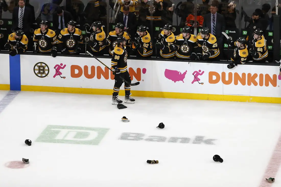 Hats litter the ice as Boston Bruins right wing David Pastrnak (88) is congratulated by teammates after scoring his third goal of the game against the Philadelphia Flyers during the second period at TD Garden in Boston on Jan 13, 2022. (Winslow Townson/USA TODAY Sports via Field Level Media)