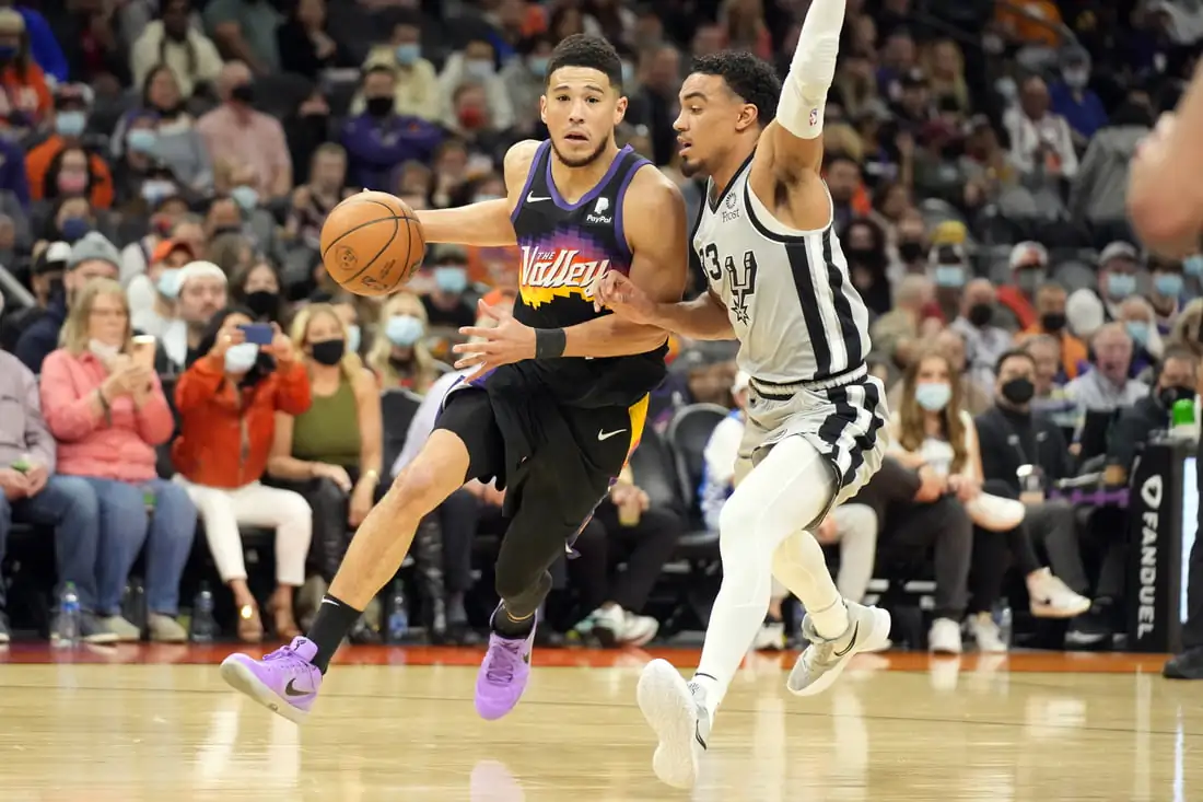 Phoenix Suns guard Devin Booker (1) controls the ball defended by San Antonio Spurs forward Zach Collins (23) in the first half at Footprint Center in Phoenix, Ariz., on Jan 30, 2022. (Rick Scuteri/USA TODAY Sports via Field Level Media)