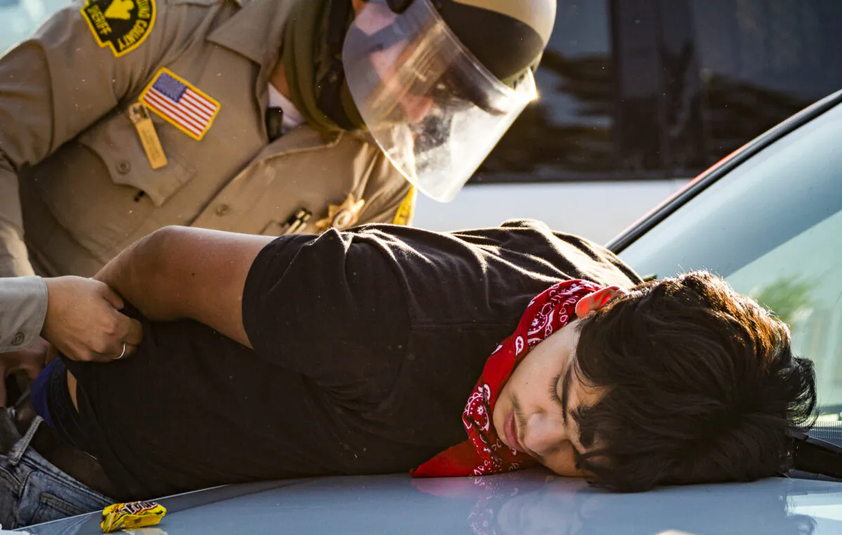 A man is arrested by a Sheriff's Deputy in Yucaipa, Calif., on Aug. 1, 2020. (John Fredricks/The Epoch Times)