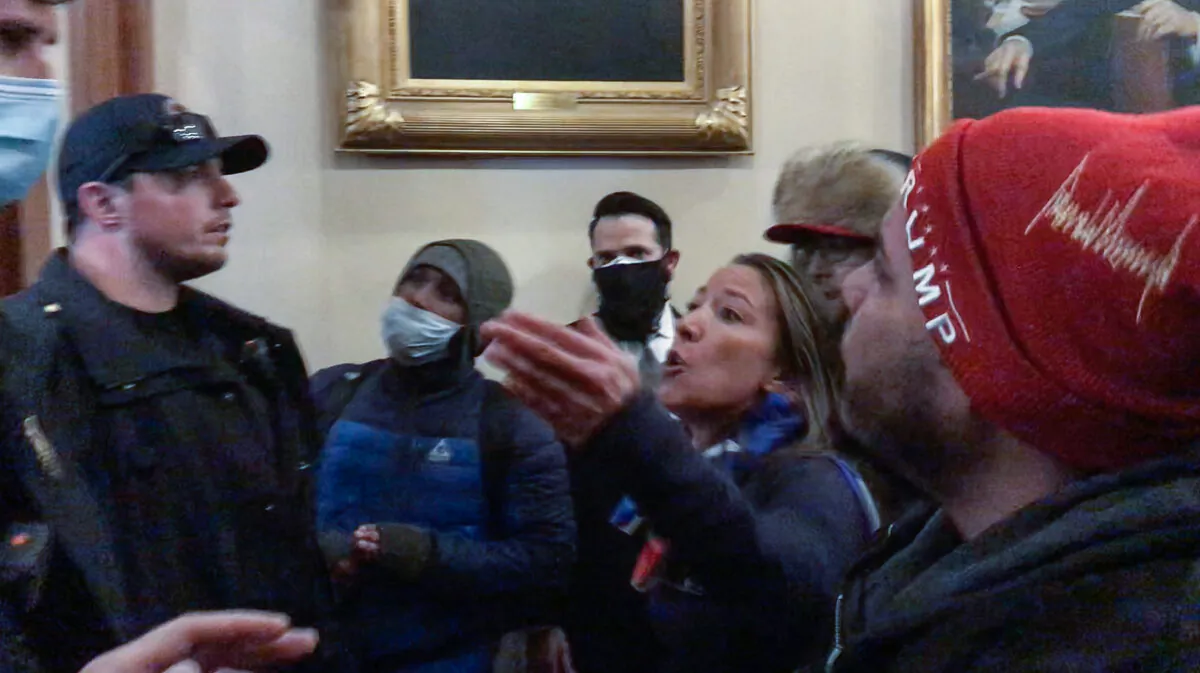 Moments before being shot to death, Ashli Babbitt confronts three police offers for not stopping the vandalism outside the U.S. House. (Video Still / ©Tayler Hansen)