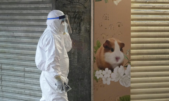 A staff member from the Agriculture, Fisheries, and Conservation Department walks past a pet shop which was closed after some pet hamsters tested positive for the coronavirus, in Hong Kong, on Jan. 18, 2022. (Kin Cheung/AP Photo)