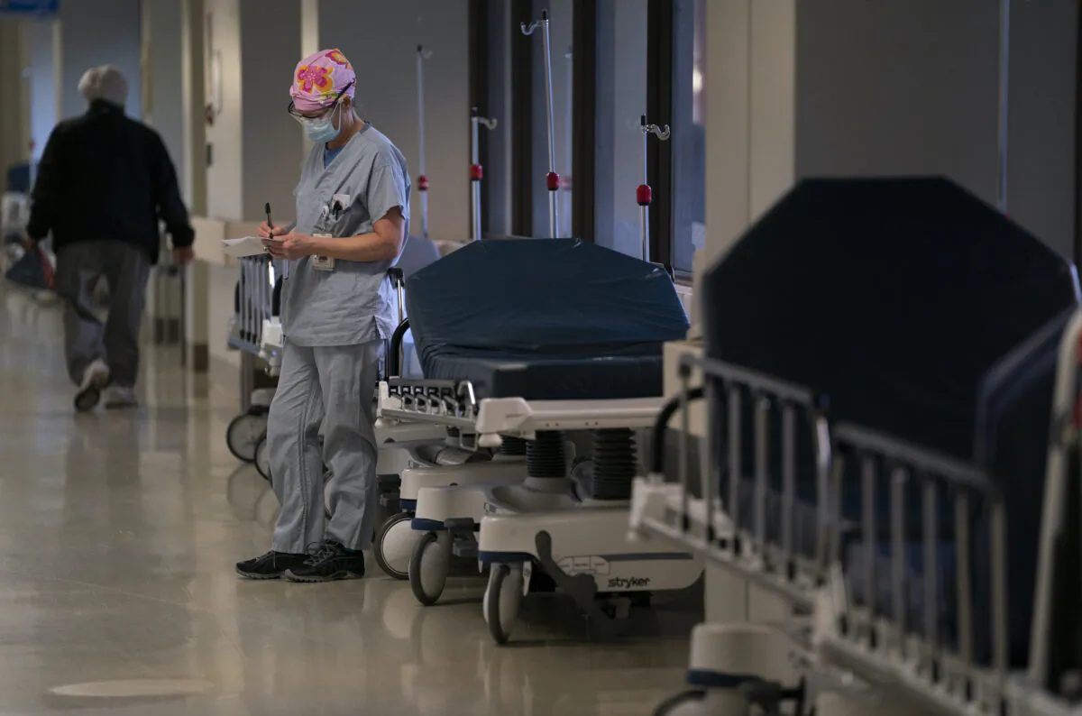 An ICU nurse takes a moment to write some notes during her shift at St. Paul’s Hospital in Vancouver on Dec. 4, 2020. (Jonathan Hayward/The Canadian Press)