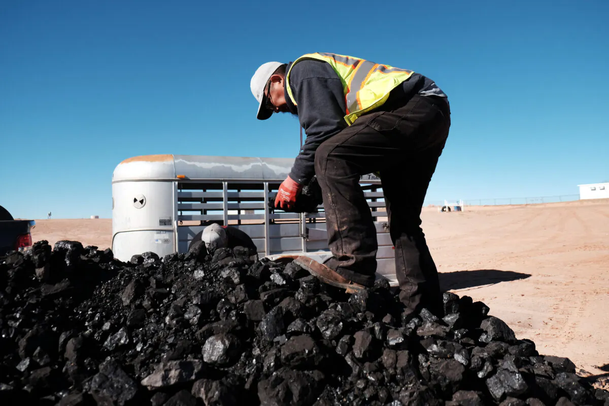 A Navajo Nation volunteer collects coal to distribute to Native Americans in need at a free wood collection site in Tuba City, Ariz., on Dec. 17, 2021. (Spencer Platt/Getty Images)