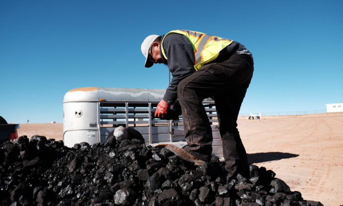 A Navajo Nation volunteer collects coal to distribute to Native Americans in need at a free wood collection site in Tuba City, Ariz., on Dec. 17, 2021. (Spencer Platt/Getty Images)