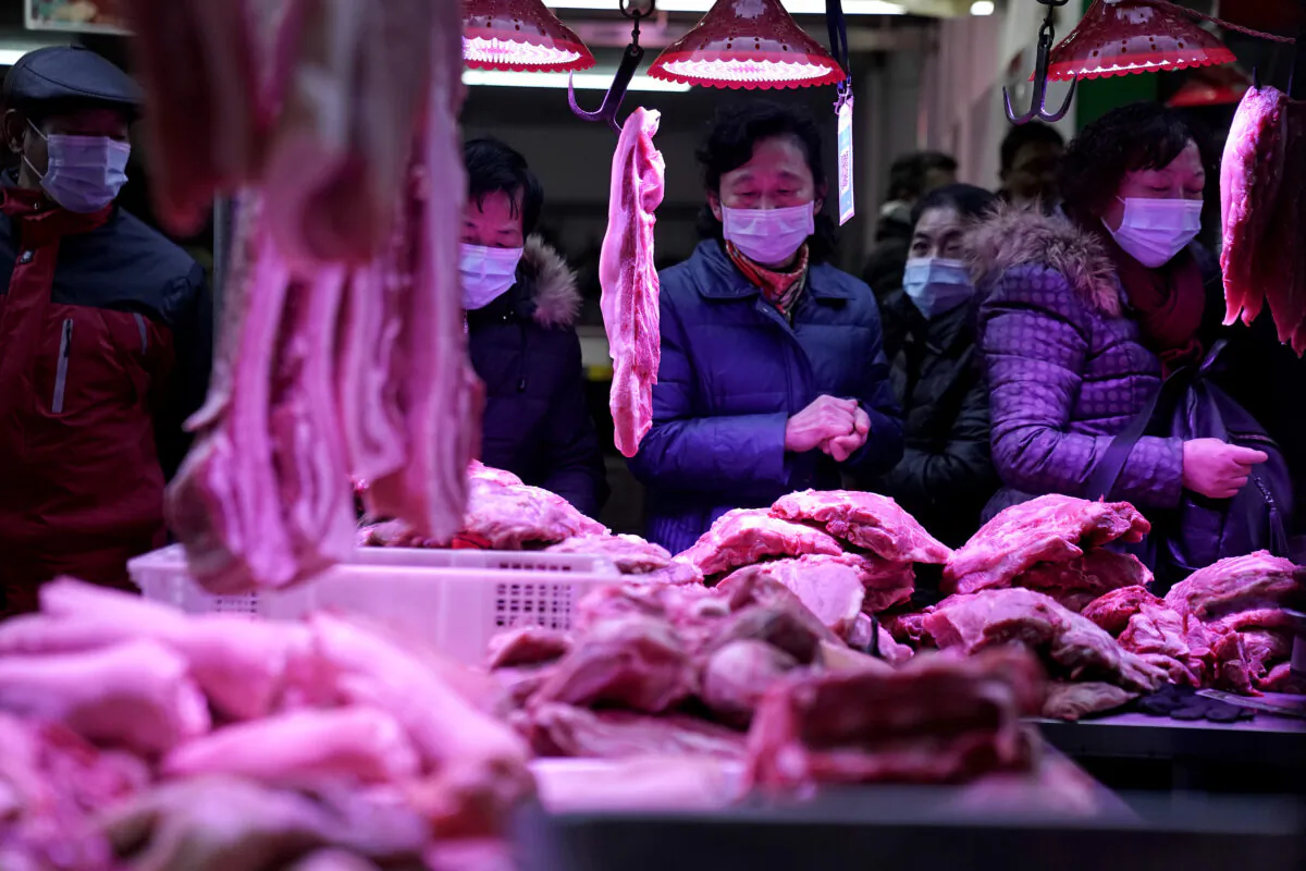 Residents buy pork to make sausage for the upcoming Chinese Spring Festival on a street famous for its sausages in Wuhan, Hubei Province, China, on Dec. 31, 2020. (Getty Images)
