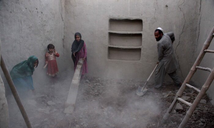 A file image of a family clearing rubble from their house after it was damaged by an earthquake in the Behsud district of Afghanistan’s eastern Nangarhar Province on Oct. 28, 2015. (Noorullah Shirzada/AFP via Getty Images)
