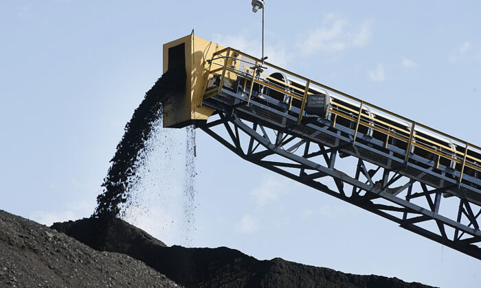 Coal falls off a conveyer belt as it's off loaded from trucks from local coal mines at the Savage Energy Terminal on Aug. 26, 2016, in Price, Utah. (George Frey/Getty Images