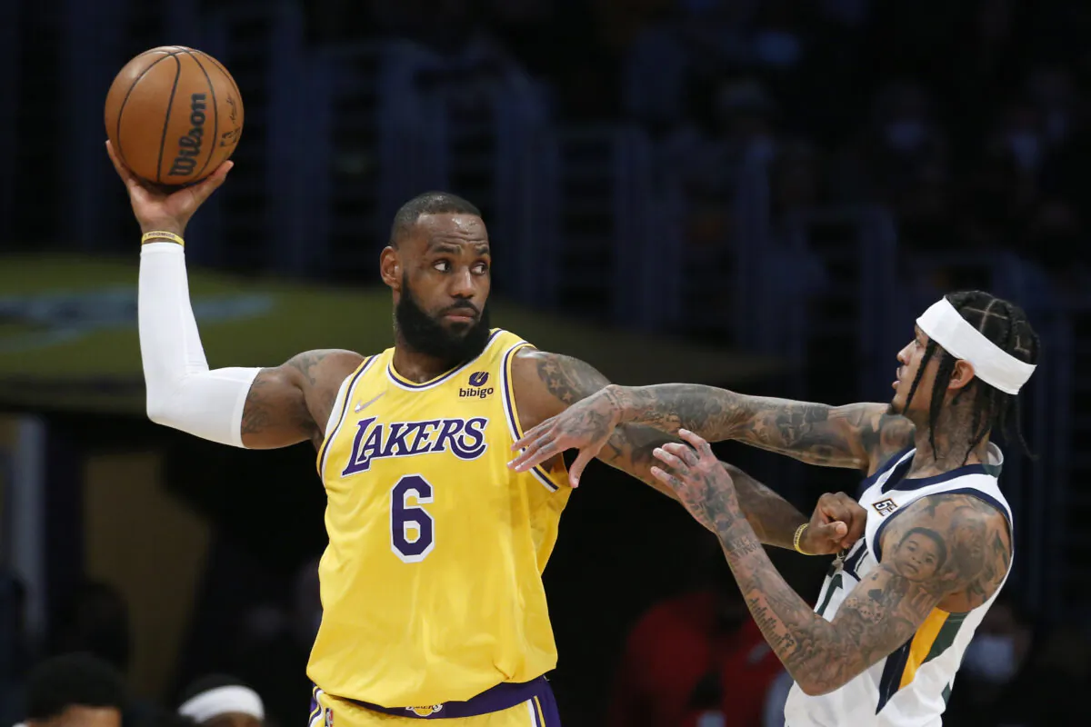 Los Angeles Lakers forward LeBron James (6) is defended by Utah Jazz guard Jordan Clarkson, right, during the first half of an NBA basketball game in Los Angeles on Jan. 17, 2022. (AP Photo/Ringo H.W. Chiu)