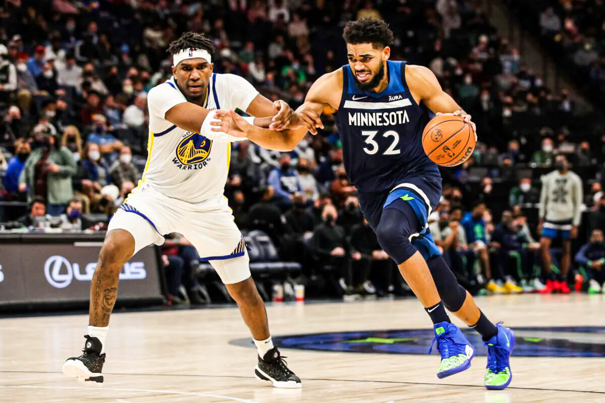 Karl-Anthony Towns #32 of the Minnesota Timberwolves drives to the basket while Kevon Looney #5 of the Golden State Warriors defends in the third quarter of the game at Target Center in Minneapolis, Minnesota. on Jan. 16, 2022. (David Berding/Getty Images)