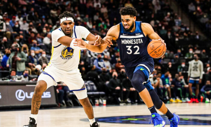 Karl-Anthony Towns #32 of the Minnesota Timberwolves drives to the basket while Kevon Looney #5 of the Golden State Warriors defends in the third quarter of the game at Target Center in Minneapolis, Minnesota. on Jan. 16, 2022. (David Berding/Getty Images)