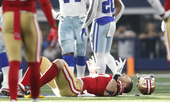 San Francisco 49ers defensive end Nick Bosa (97) lays on the field with an injury in the second quarter against the Dallas Cowboys in a NFC Wild Card playoff football game at AT&T Stadium on Jan 16, 2022 at Arlington, Texas. (Tim Heitman-USA TODAY Sports/via Field Level Media)