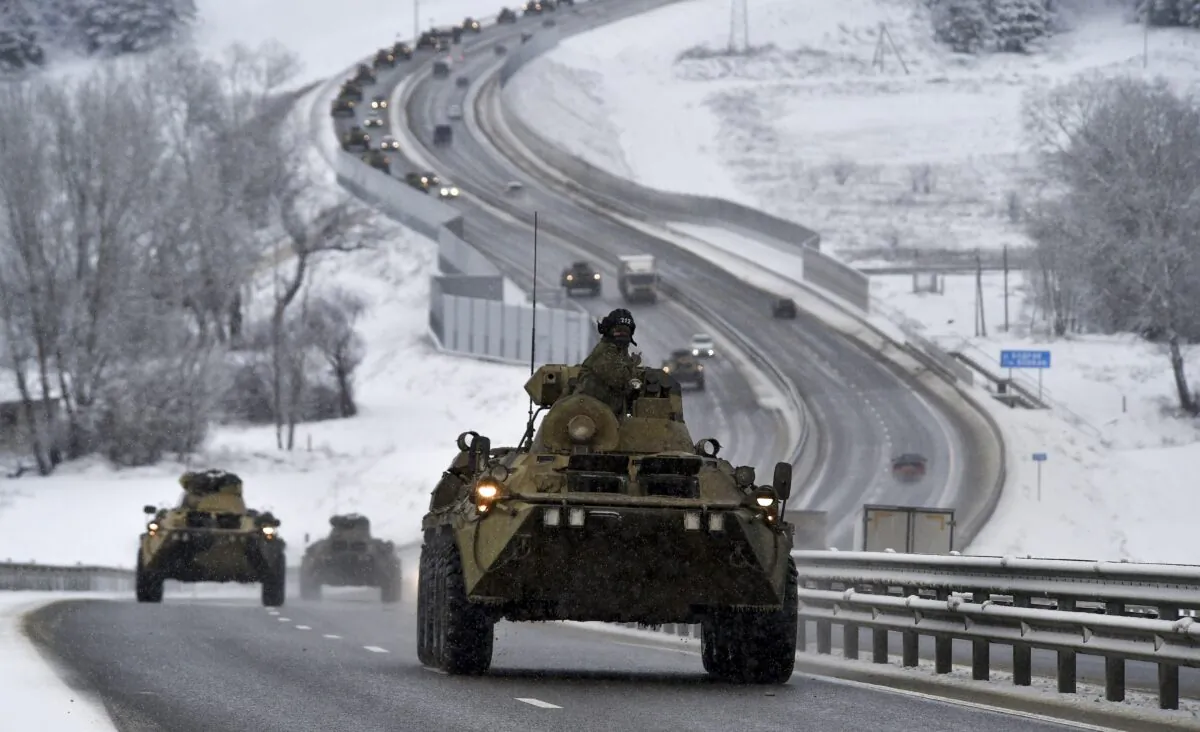A convoy of Russian armored vehicles moves along a highway in Crimea, on Jan. 18, 2022. (AP Photo)