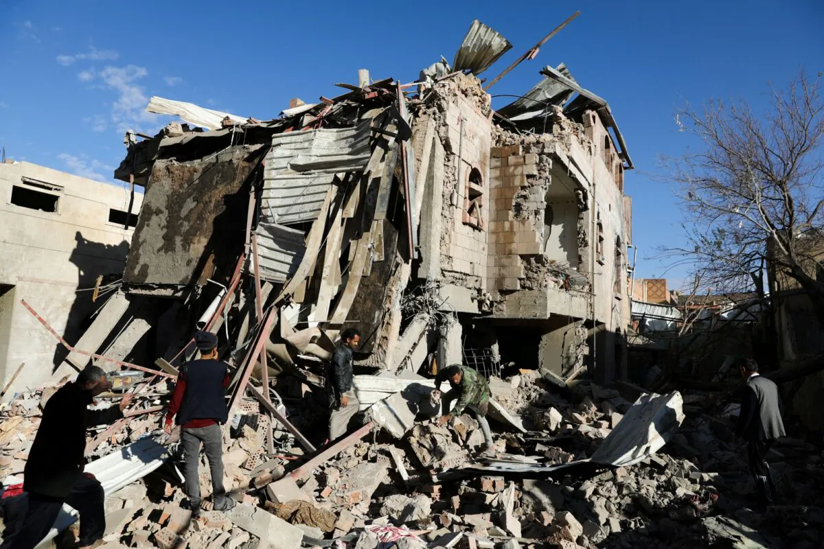 Rescuers remove debris at the site of Saudi-led air strikes in Sanaa, Yemen, on Jan. 18, 2022. (Khaled Abdullah/Reuters)