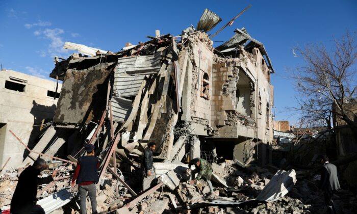 Rescuers remove debris at the site of Saudi-led air strikes in Sanaa, Yemen, on Jan. 18, 2022. (Khaled Abdullah/Reuters)