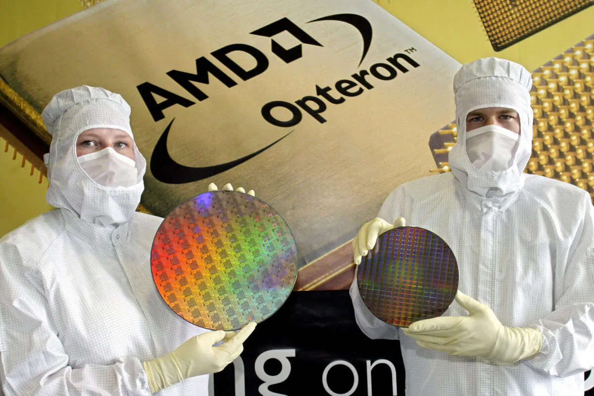 The workers of US' Advances Micro Systems (AMD) displaying a so-called 'wafer' in the company's work in Dresden, Saxony on 17 May 2004. (Norbert Millauer/DDP/AFP via Getty Images)