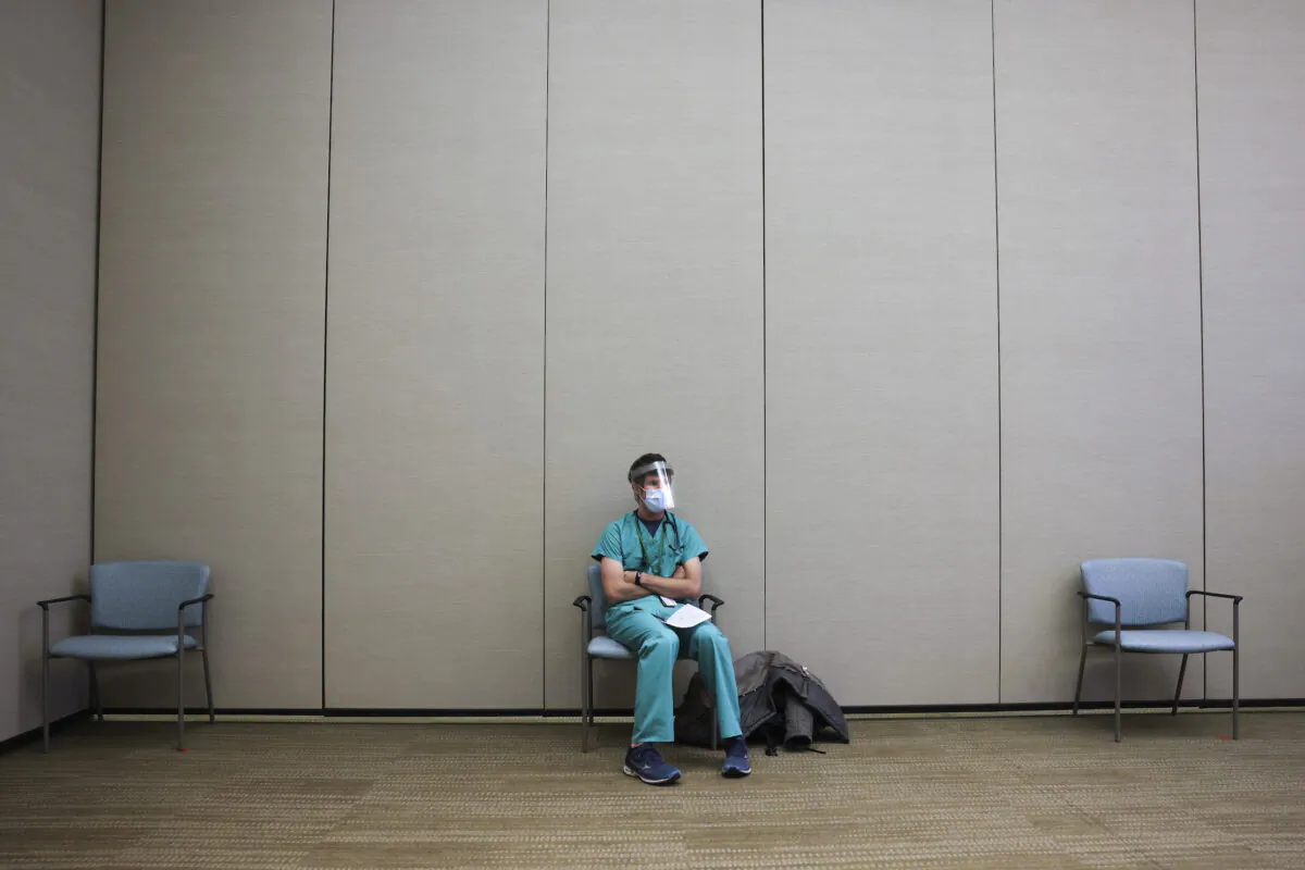 An internal medicine resident sits in a waiting area before receiving a dose of the Pfizer-BioNTech COVID-19 vaccine at a hospital in Aurora, Col., on Dec. 16, 2020. (Michael Ciaglo/Getty Images)
