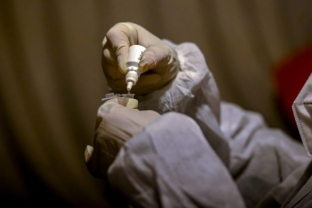 A health worker conducts a Rapid Antigen Test (RAT) of a person for the Covid-19 coronavirus at a testing center in Srinagar on January 17, 2022. (Tauseef Mastafa/AFP via Getty Images)
