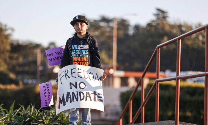 A young boy holds a sign during a rally against vaccine mandates at the Golden Gate Bridge in San Francisco, Calif. on Nov. 11, 2021. (Justin Sullivan/Getty Images)