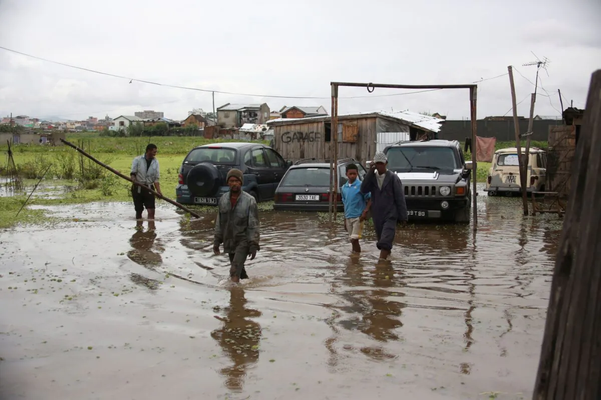 Workers wade through floodwater after heavy rain in Antananarivo, Madagascar, on Jan. 19, 2022. (Alexander Joe/AP Photo)