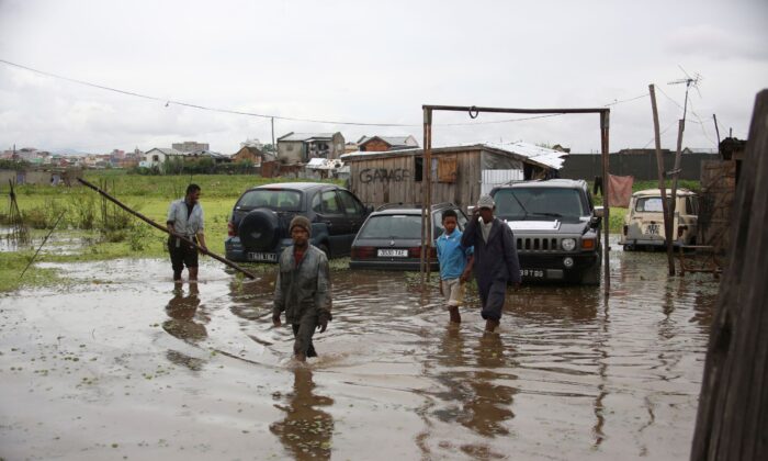 Workers wade through floodwater after heavy rain in Antananarivo, Madagascar, on Jan. 19, 2022. (Alexander Joe/AP Photo)