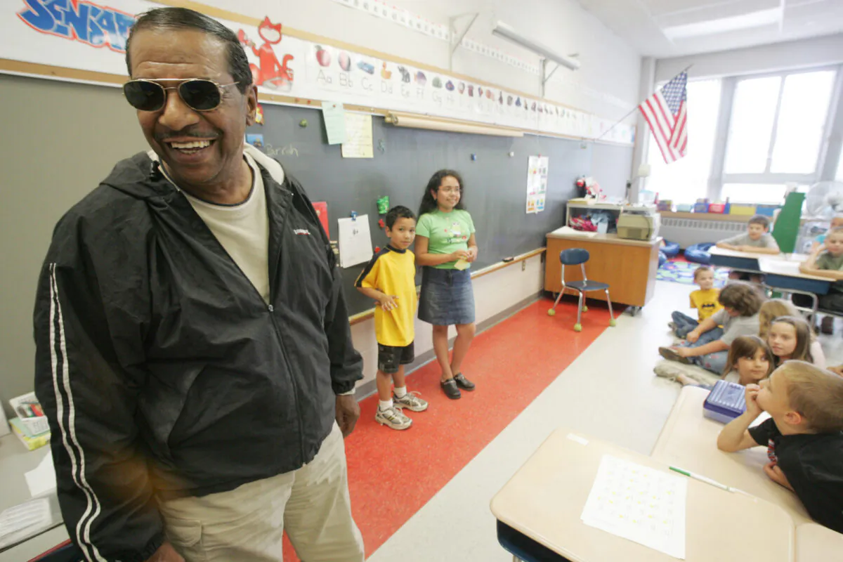 Singer Fred Parris, famous for singing "In the Still of the Night," with the 1950s harmony group The Five Satins, is introduced by his grandchildren Brandon Parris, 7, background left, and Savannah Parris, 9, during a visit to Hanover Elementary School in Meriden, Conn., on June 16, 2005. (Chris Angileri/Record-Journal via AP)