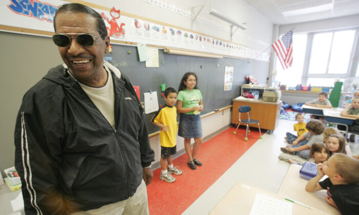 Singer Fred Parris, famous for singing "In the Still of the Night," with the 1950s harmony group The Five Satins, is introduced by his grandchildren Brandon Parris, 7, background left, and Savannah Parris, 9, during a visit to Hanover Elementary School in Meriden, Conn., on June 16, 2005. (Chris Angileri/Record-Journal via AP)