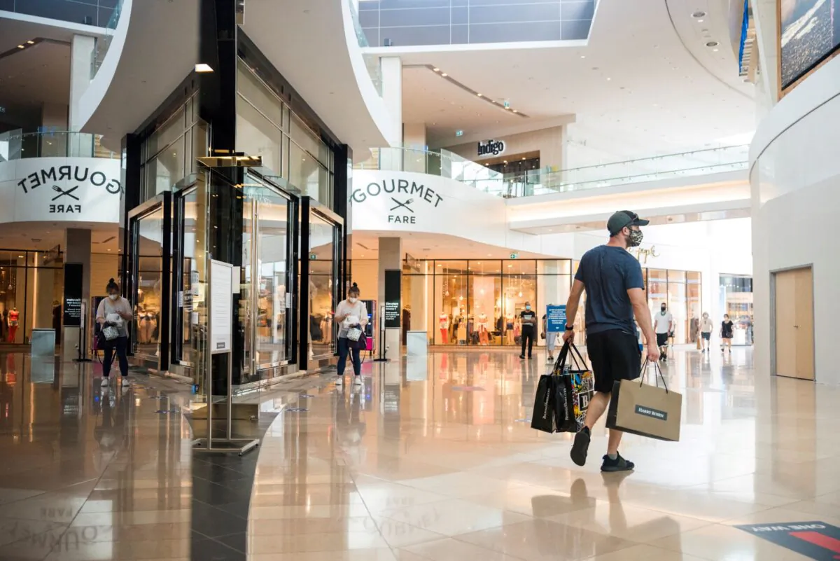 A shopper holds multiple shopping bags in Sherway Gardens mall in Toronto on June 30, 2021. (Alex Filipe/Reuters)